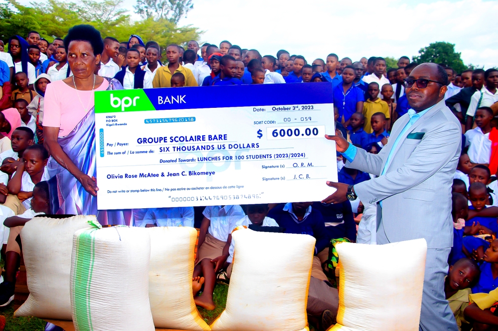 Jean Bikomeye’s mother, Alphonsine Nyirabusitari , presented the $6,000 cheque to the headmaster of GS Bare.
