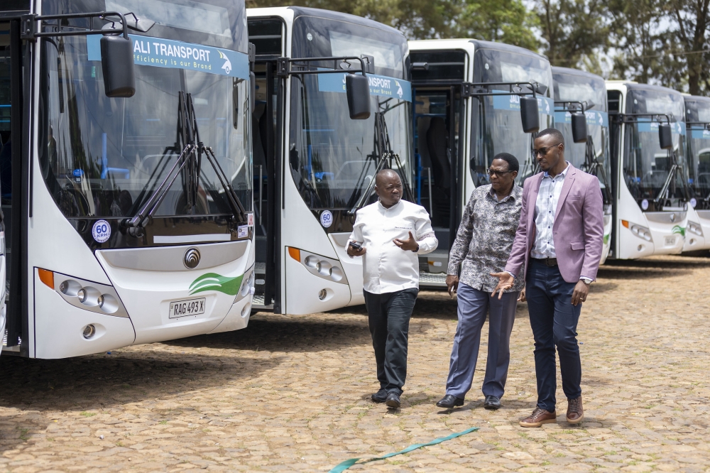 Kigali’s Vice-Mayor in charge of Urbanisation and Infrastructure, Merard Mpabwanamaguru (left) chats with Dodo Twahirwa, the CEO of Jali Transport (C) as Jali unveiled 20 new buses on Friday. OLIVIER MUGWIZA