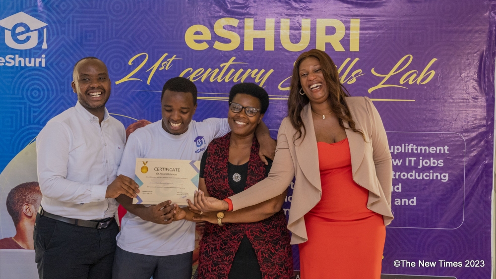 One of the trainees (2nd left) poses with officials as he receives a certificate at the completion
of the hands-on software training at eShuri 21st Century Skills Lab Programme on October 13.