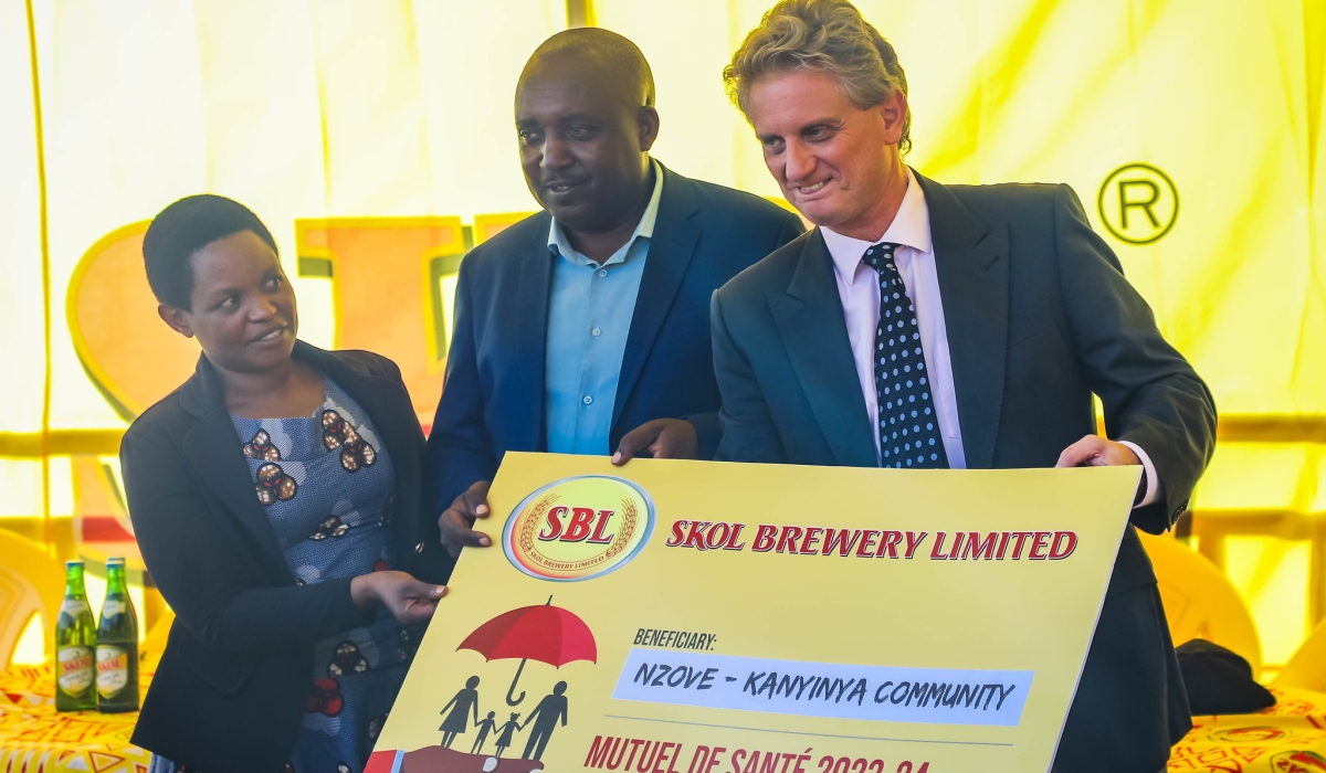 Eric Gilson, the General Manager of SKOL hands over the donation of community health insurance, Mutuelle de Santé, to 842 individuals residing in the neighbourhood of the brewery in Nzove. Dan Gatsinzi