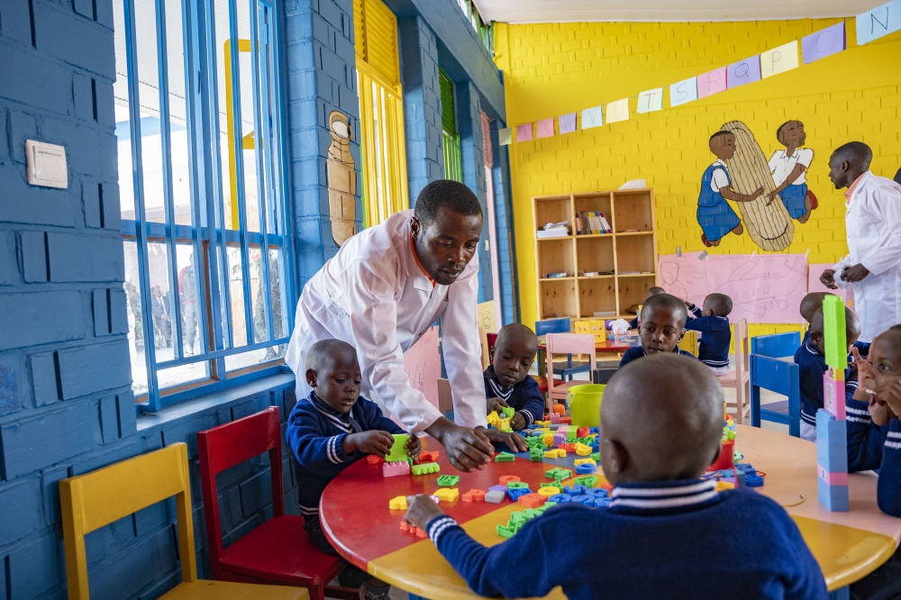 A caretaker helps children at the newly constructed early childhood development center at Rugerero Model Village. Photo by Emmanuel Dushimimana