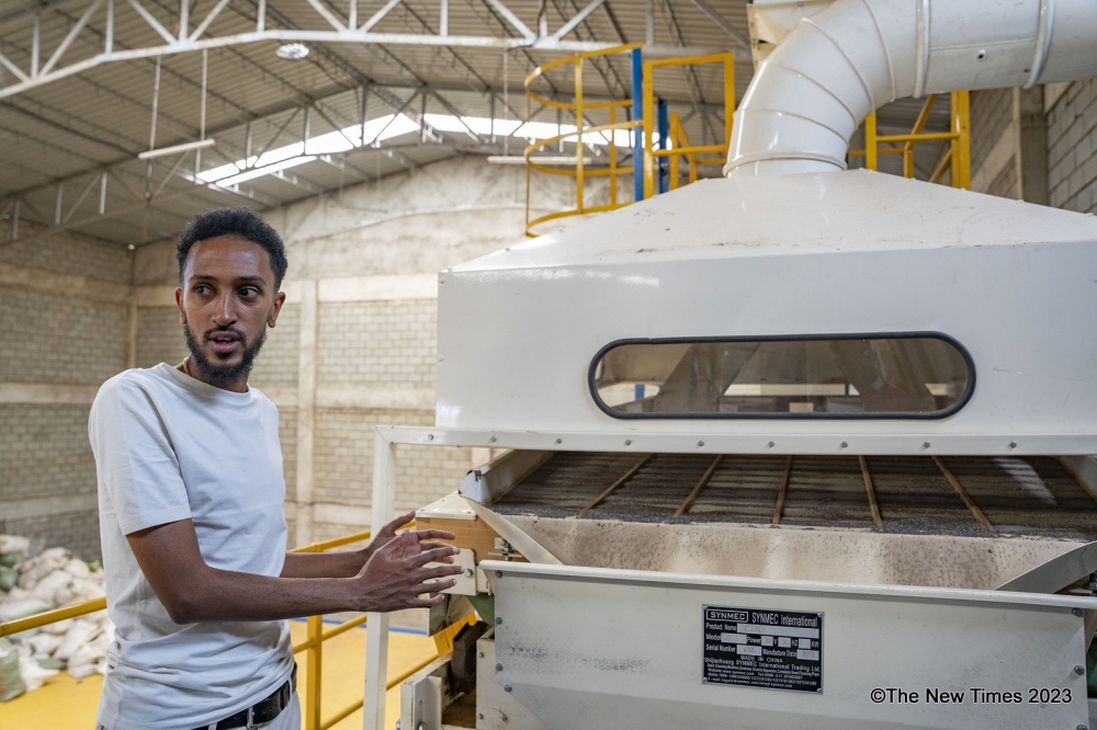 Ethiopian investor Yared Gebremichael explains how one of the machines works at his cleaning and sorting factory in Rugende, Gasabo District in Kigali City. PHOTOS BY EMMANUEL DUSHIMIMANA