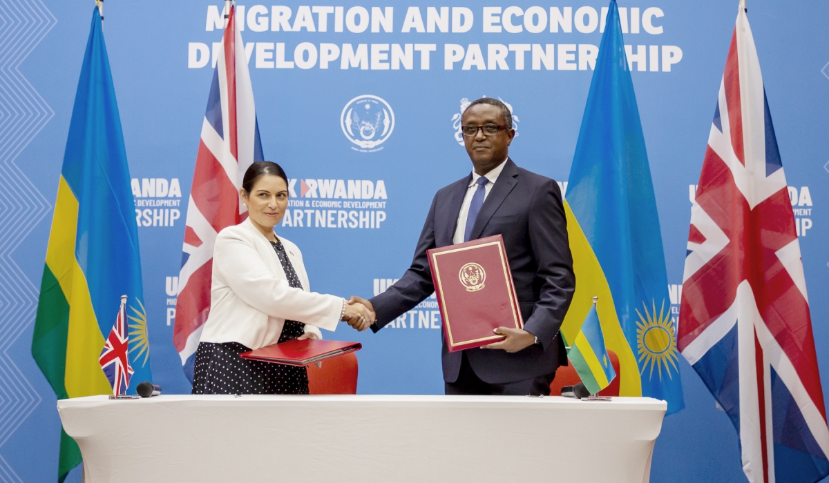 The Minister of Foreign Affairs and International Cooperation Dr. Vincent Biruta and Priti Patel, the former Home Secretary of the United Kingdom exchange the documents after signing the deal in Kigali on April 14,2022. PHOTO BY OLIVIER MUGWIZA