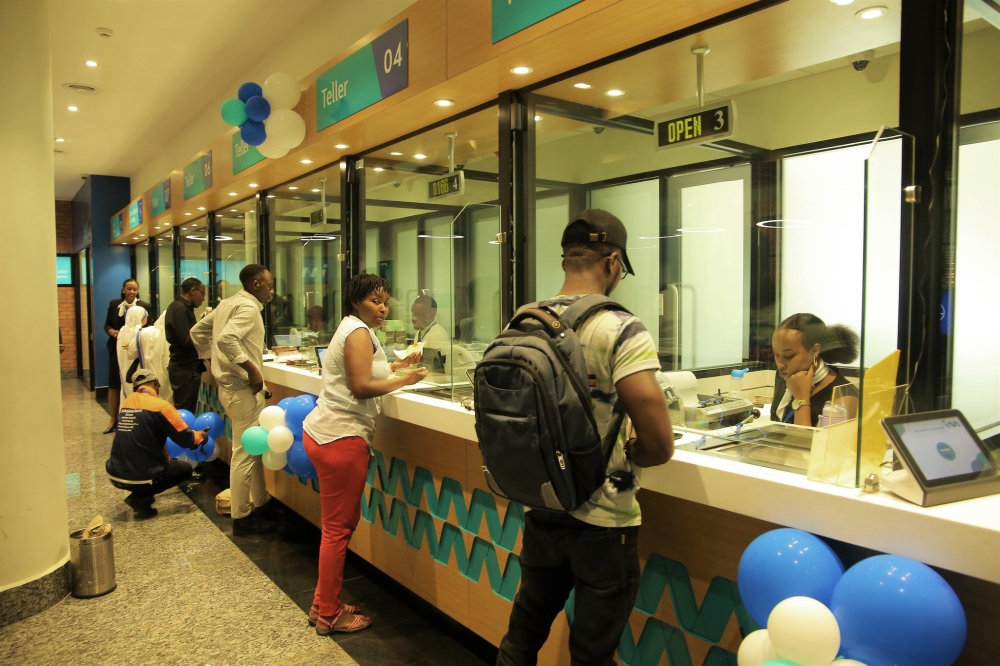 Bank tellers serve customers at I&M Bank headquarters in Kigali. Craish Bahizi