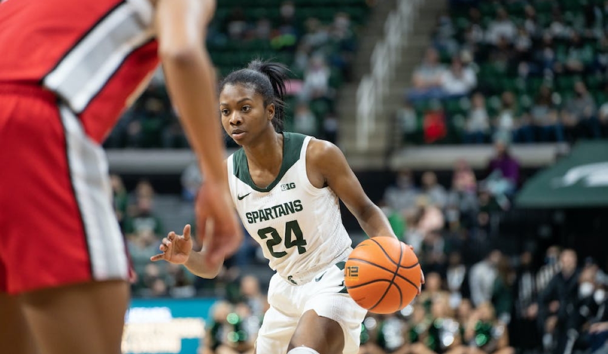Point guard Nia Clouden (24) dribbles up the court. The Spartans lost 61-55 against Ohio State University at the Breslin Center on Feb. 27, 2022.
