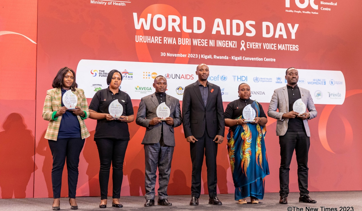 Minister of Health Dr Sabin Nsanzimana (3rd right) poses for a photo with individuals and representatives of organisations who were acknowledged for their vital contribution to the fight against AIDS during the World AIDS Day event in Kigali on Thursday, November 30. During his address, Nsanzimana encouraged young individuals to undergo
testing and start treatment, emphasising that the illness is still prevalent. PHOTOS BY DAN GATSINZI