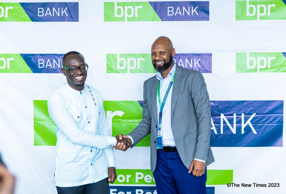 Innocent Ntwali, the Head of Retail Banking at BPR Bank and Bobson Rugambwa, the CEO of MVend Ltd shake hands during the launch of Gwiza app  on Friday, December 1. All photos by Dan Gatsinzi