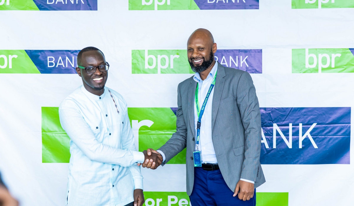 Innocent Ntwali, the Head of Retail Banking at BPR Bank and Bobson Rugambwa, the CEO of MVend Ltd shake hands during the launch of Gwiza app  on Friday, December 1. All photos by Dan Gatsinzi