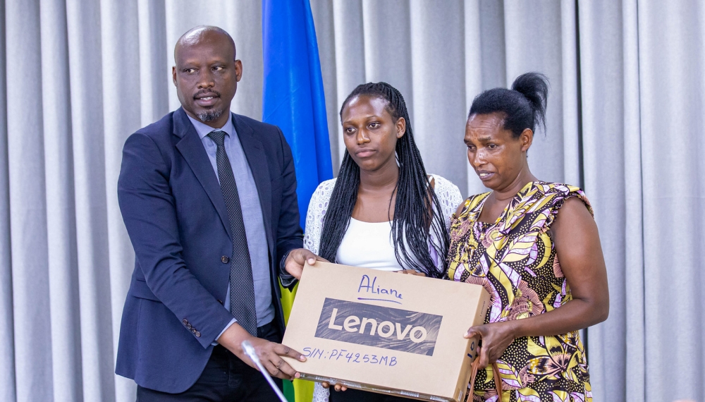 Permanent Secretary at the Ministry of Education, Charles Karakye hands over a laptop to Aliane Iranzi, the best performer  in Business and Administration (College APPEC) on December 4. Dan Gatsinzi