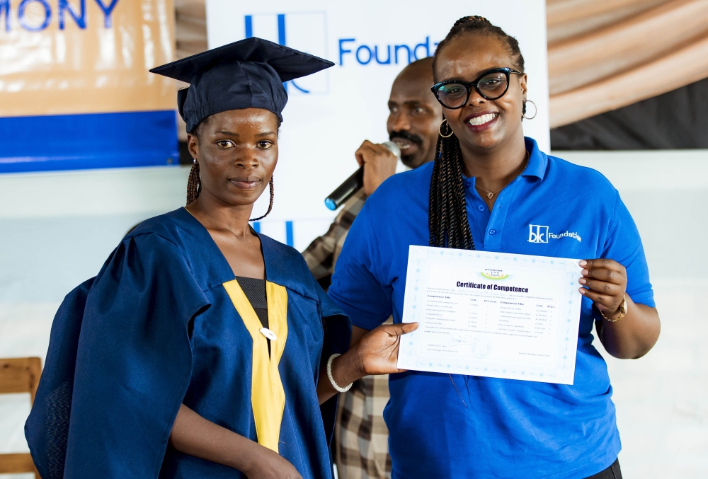 Ingrid Karangwayire , Executive Secretary of BK Foundation gives a certificate to one of  the 78  graduates at the event. Courtesy