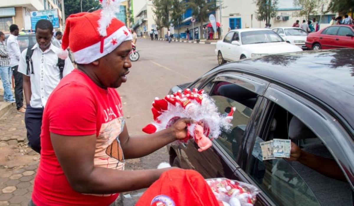 A hawker sells toys to a customer in downtown Kigali. The festive season involves celebrations that require spending money on food, gifts, or outings. File photo