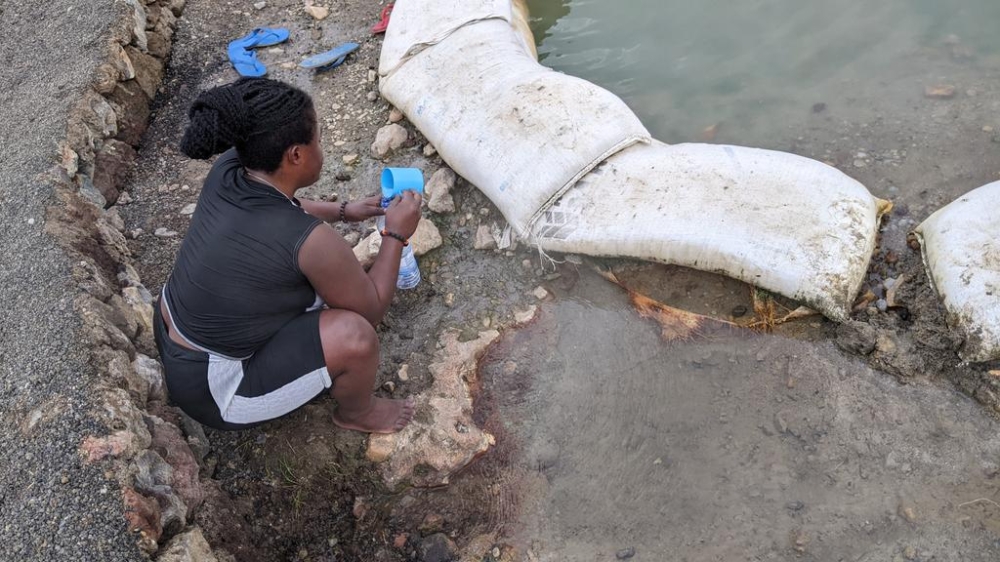 A women drawing springs at Nyamyumba