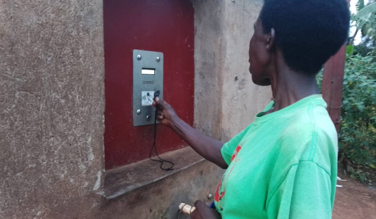 Xavela Gisubizo uses a smart metre at a water point she runs in Kayonza. Courtesy photos
