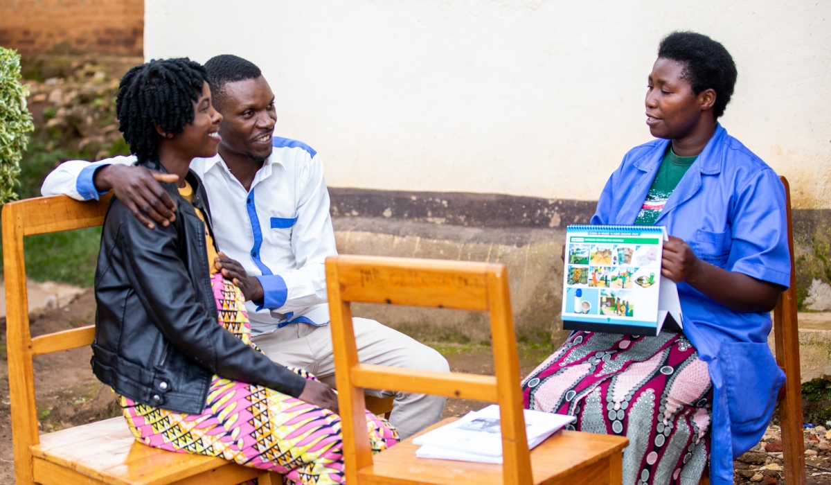 A pregnant woman with her husband meet with a community health worker in Karongi District. Photo by Olivier Mugwiza