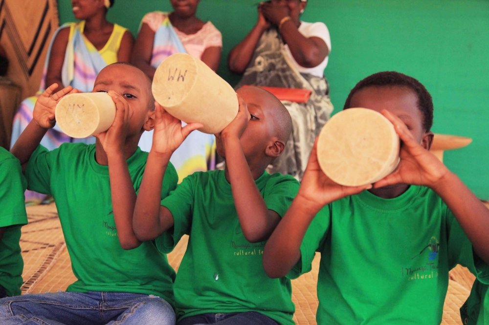 Children drink milk during Umuganura in Nyanza District. Sam Ngendahimana