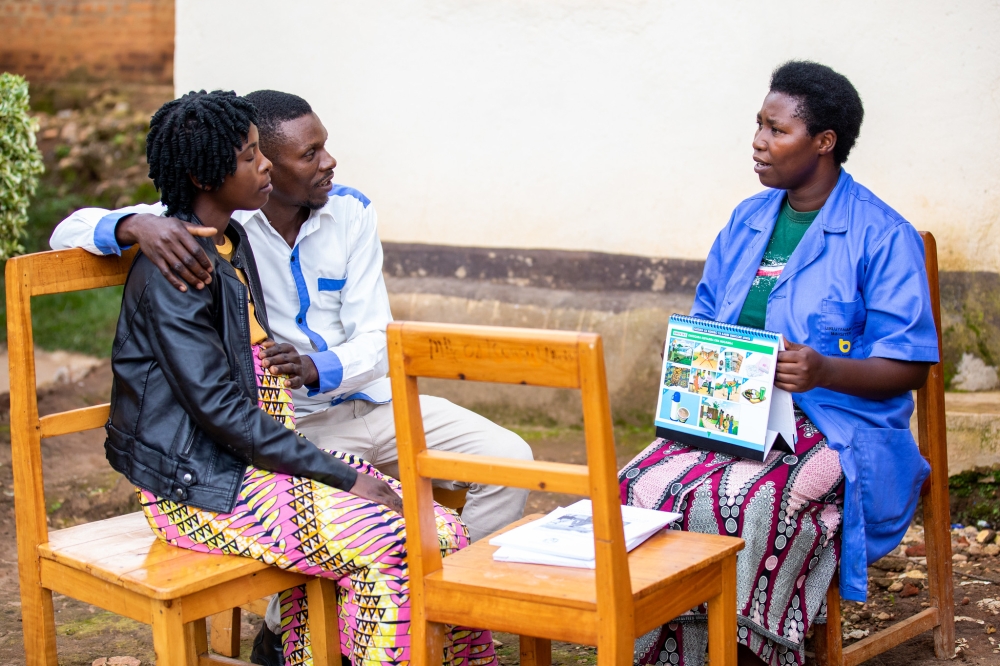 A community health worker interacts with a pregnant woman with her husband at Mubuga Hospital in Karongi District on December 9, 2022. OLIVIER MUGWIZA