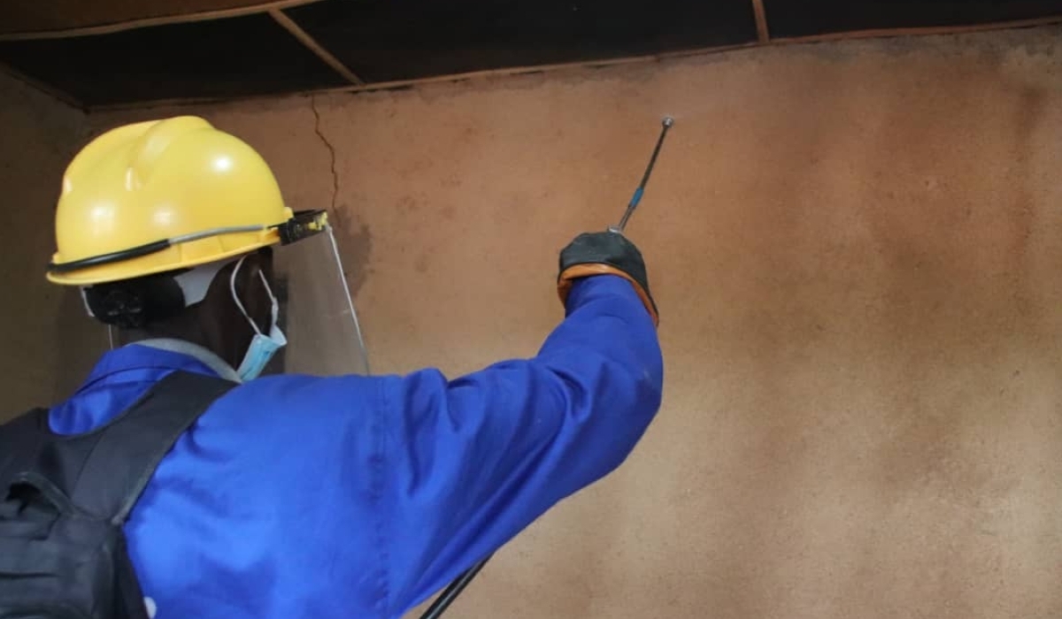 A community health worker spraying medicine to combat malaria in Ruhango district. File