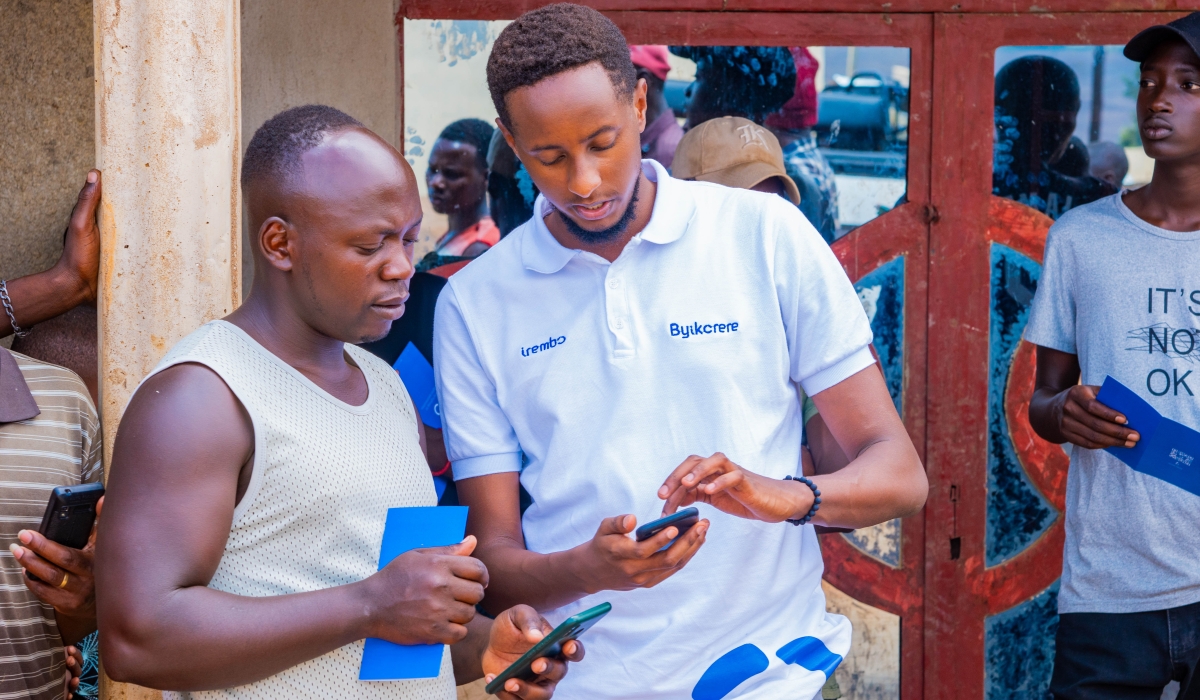 Irembo staff shows a resident how he can pay some services through Irembo online platform during their campaign. Courtesy