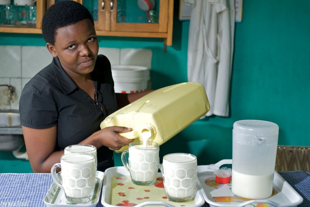 A milk seller serving customers in her milk bar in Kigali. File