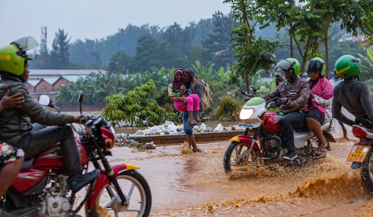 Road users wade through a flooded street in Kigali. METEO Rwanda  has alerted the public to expect significant heavy rainfall throughout the country in February, exceeding usual average. FILE