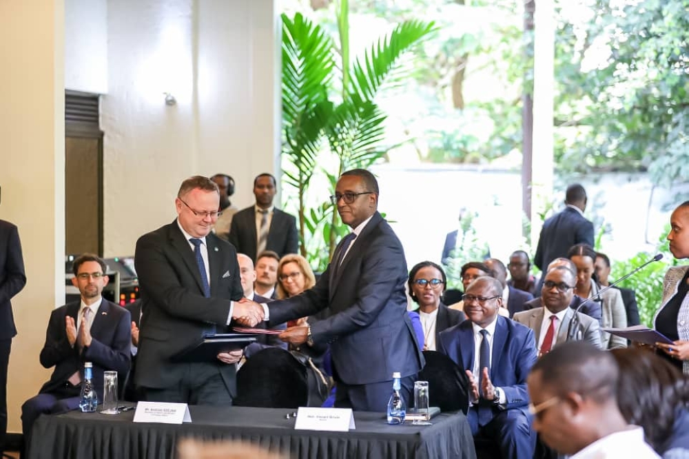 Minister of Foreign Affairs Vincent Biruta (R), and Andrzej Szejna, Polish Secretary of State in the Ministry of Foreign Affairs, exchange documents after signing cooperation agreements in trade and green technologies on Wednesday. PHOTO BY DAN GATSINZI
