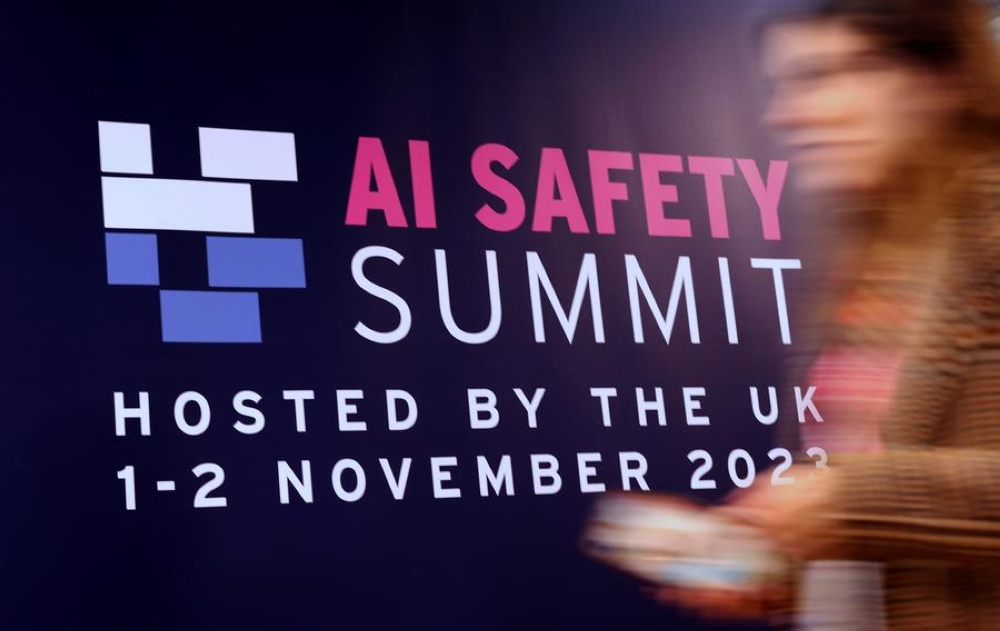 An attendee walks past a billboard of AI Safety Summit in Bletchley Park, Britain, Nov. 2, 2023. A global summit on artificial intelligence (AI) safety was held at Bletchley Park on Nov. 1 to 2. The Chinese delegation attending the summit participated in discussions on AI safety and other issues, promoted China&#039;s Global Artificial Intelligence Governance Initiative, and carried out bilateral talks with relevant countries.v(Xinhua/Li Ying)