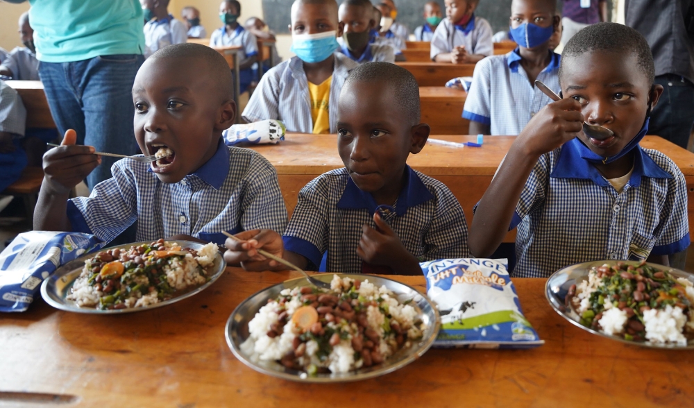 Primary school children enjoying lunch thanks to the school feeding programme. Photo: Craish Bahizi