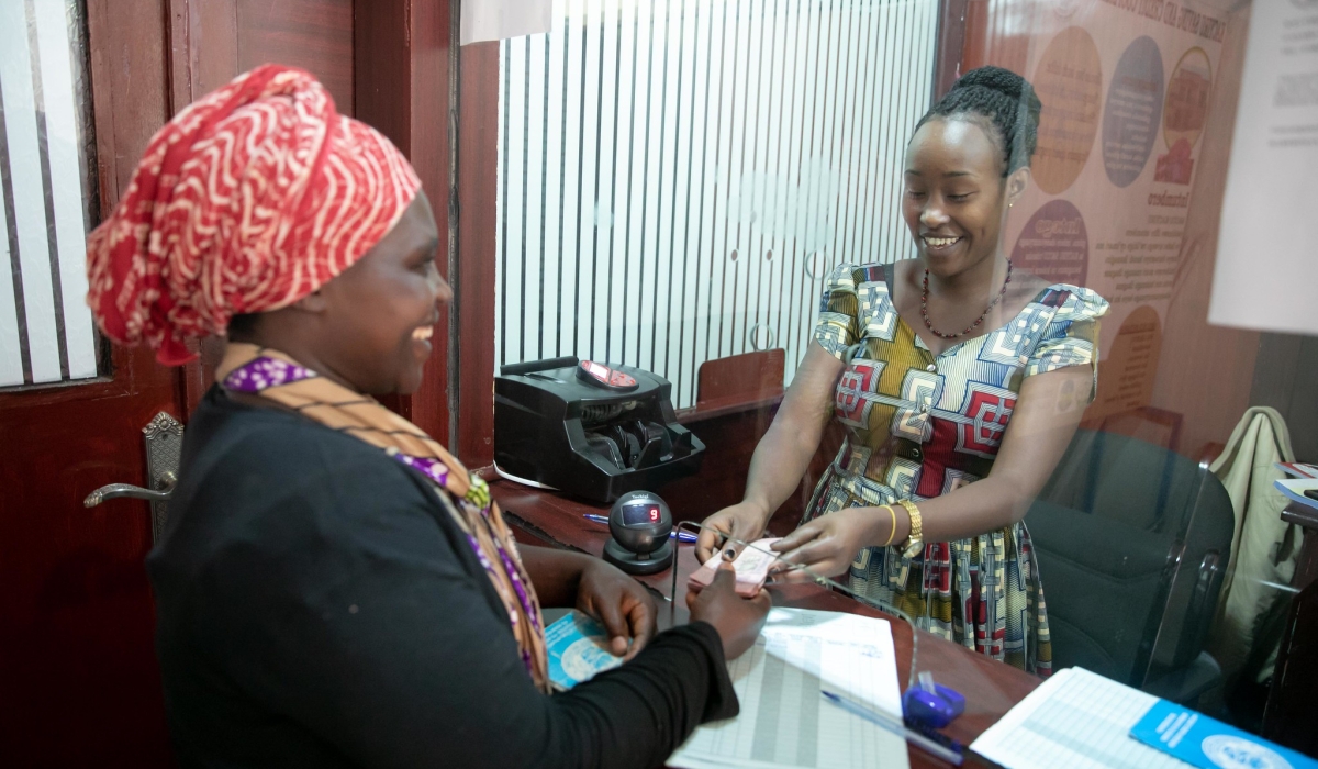 A bank teller serving a client at Kacyiru Umurenge Sacco in Kigali. File