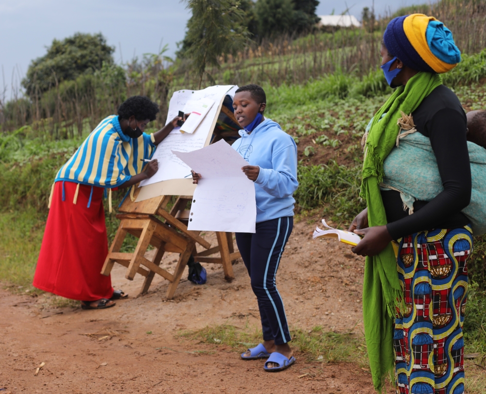 A young girl and women chair a discussion during a goal-setting meeting in Gashoro Village, Rwerere Sector, Burera District. 