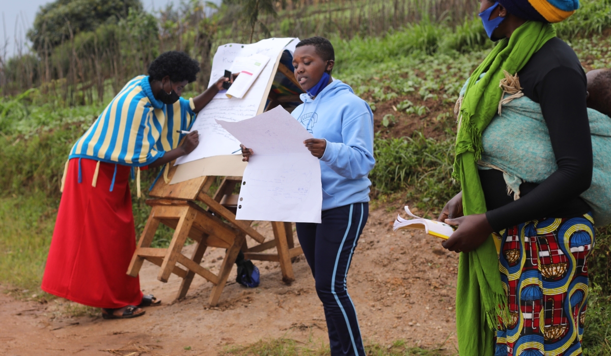 A young girl and women chair a discussion during a goal-setting meeting in Gashoro Village, Rwerere Sector, Burera District. 