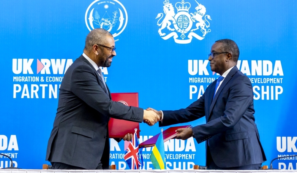 The Minister of Foreign Affairs and International Cooperation, Vincent Biruta (right), and UK Home Secretary James Cleverly shake hands after signing a new migration treaty between the two countries in Kigali, on December 5,2023. Photo by Olivier Mugwiza