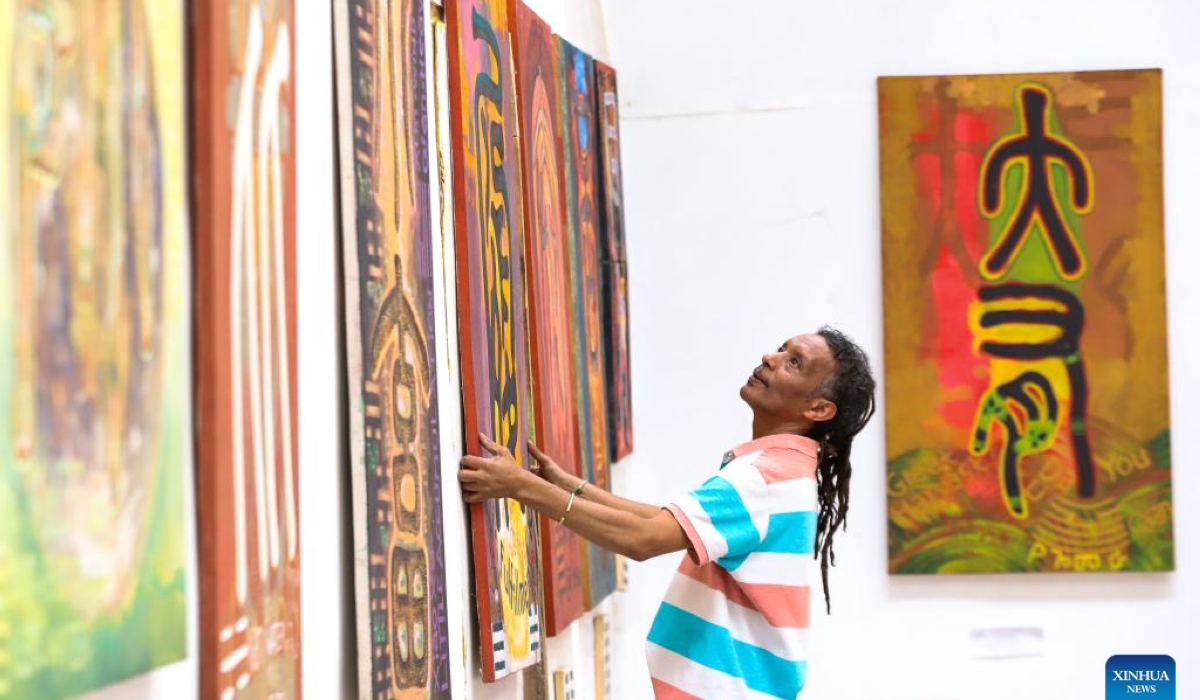 Artist Dawit Muluneh hangs one of his Chinese-character paintings on the wall for exhibition at an art gallery in Addis Ababa, Ethiopia, March 18, 2024. (Xinhua/Michael Tewelde)