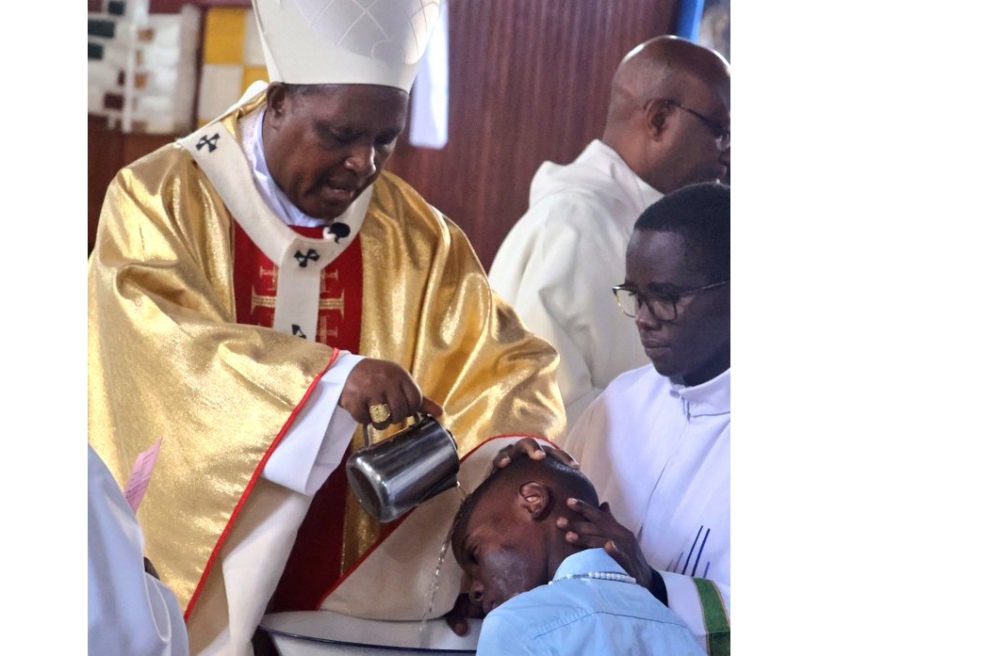The Archbishop of Kigali and President of the Council of Catholic Bishops in Rwanda, Antoine Cardinal Kambanda baptises a believer during the Easter mass at St Famille catholic church on Sunday, March 31. Courtesy