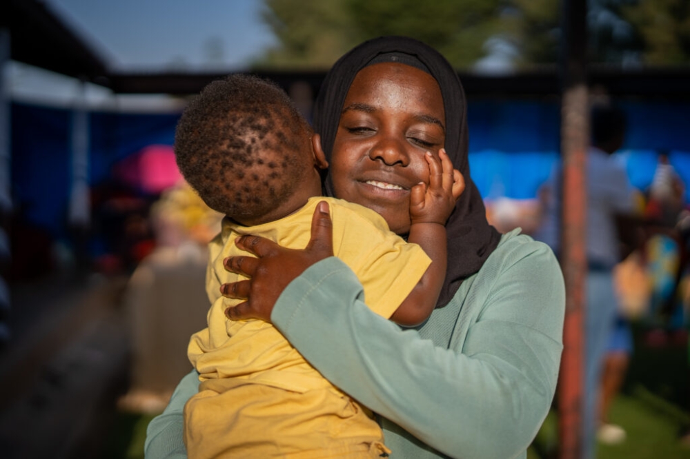 A teen mother snuggles her baby for the camera during a Women&#039;s Day event at the University of Global Health Equity (UGHE) in Butaro, Burera District, in March 2023. PHOTO BY UGHE.