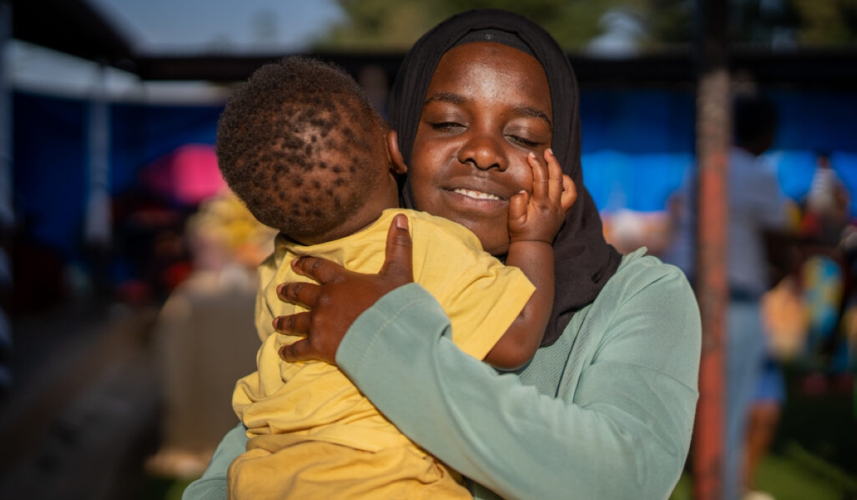 A teen mother snuggles her baby for the camera during a Women&#039;s Day event at the University of Global Health Equity (UGHE) in Butaro, Burera District, in March 2023. PHOTO BY UGHE.