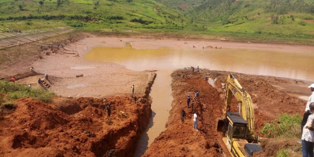 An excavator exhumes remains of Tutsi victims at a dam in Gatsibo. File