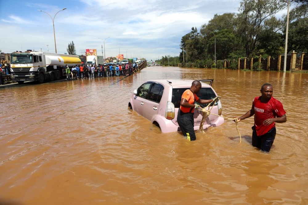 People pull a car submerged in flood water along Thika Road in Nairobi, capital of Kenya, on May 1, 2024. (Photo by Joy Nabukewa/Xinhua)