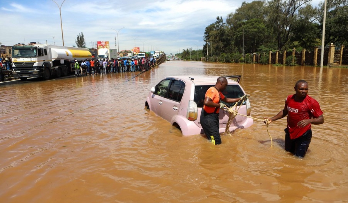 People pull a car submerged in flood water along Thika Road in Nairobi, capital of Kenya, on May 1, 2024. (Photo by Joy Nabukewa/Xinhua)