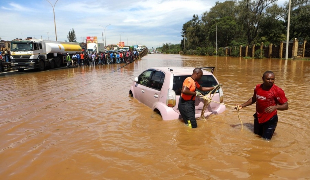 People pull a car submerged in flood water along Thika Road in Nairobi, capital of Kenya, on May 1, 2024. (Photo by Joy Nabukewa. Xinhua)