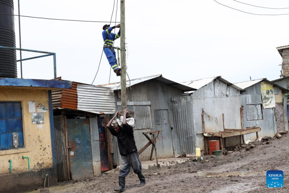 An engineer works on a power line pole in Nairobi, Kenya, May 6, 2024. UN humanitarians said on Monday nearly 750,000 people were affected by flooding in eastern Africa, with 234,000 displaced and more than 236 killed - more than 229 in Kenya alone.