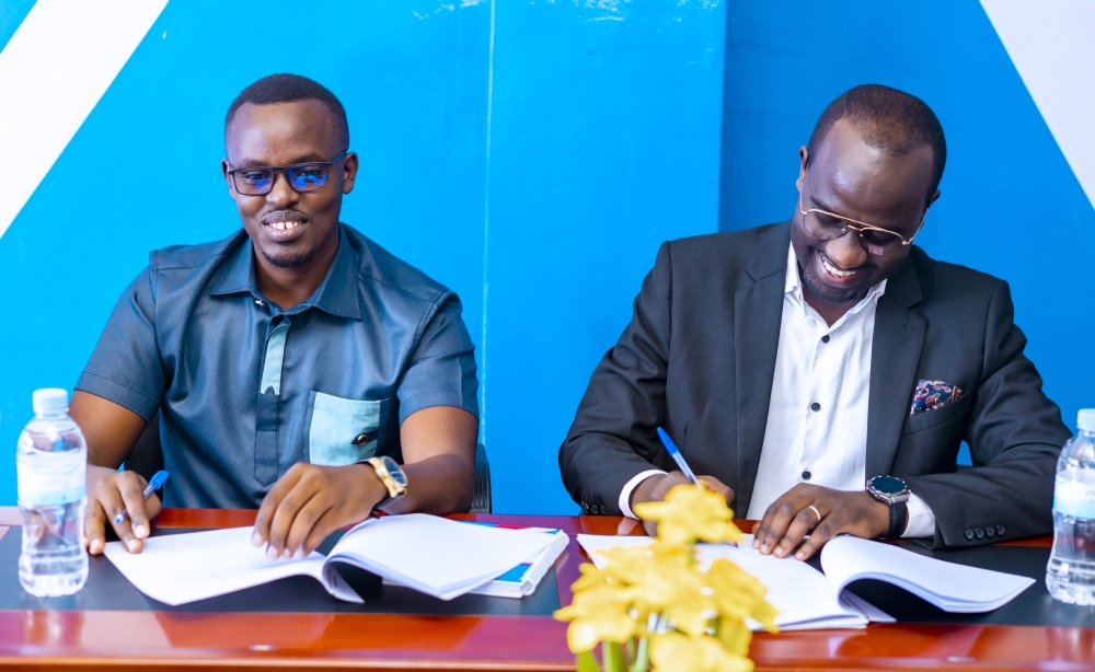 Felix Nkundimana, the CEO of Jali Finance and Frank Mugisha, the former CEO of Koi Pay sign  the agreement in Kigali. Courtesy