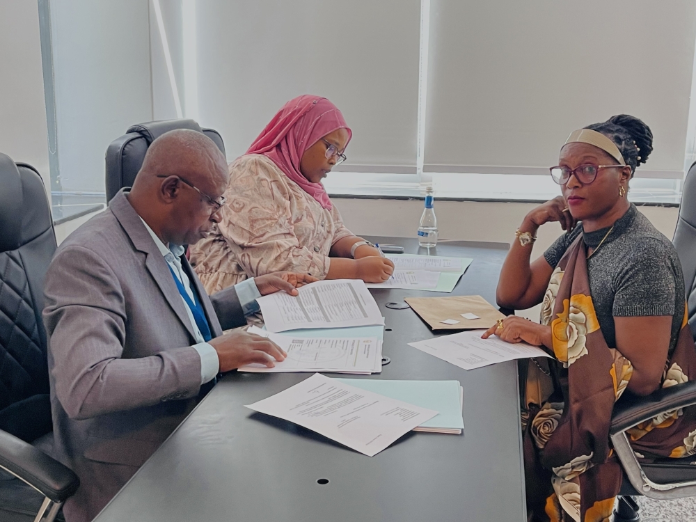 Members of NEC staff (L) check documents of one of aspirants who seek to get a parliamentary position among 24 women MPs (30 per cent quota of 80 MPs making up the Lower House), on May 17, 2024, in Kigali