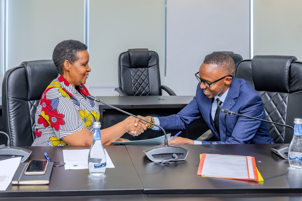 Frank Musinguzi (L) shakes hands with the Chairperson of the National Electoral Commission, Oda Gasinzigwa, after submitting his parliamentary candidature on May 22, 2024, in Kigali (courtesy)