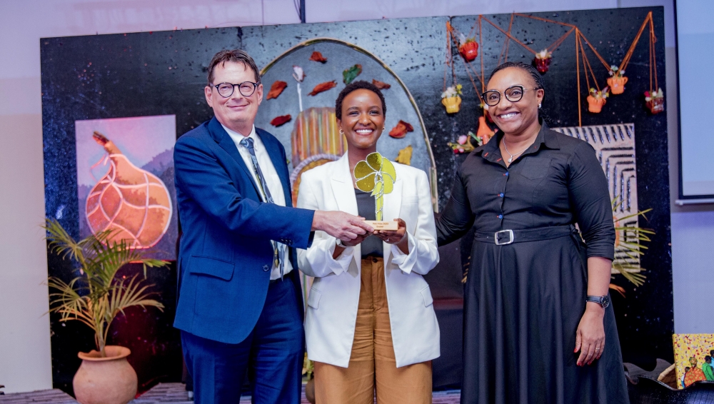 The Ambassador of Belgium to Rwanda  Bert Versmessen, Minister of Gender and Family Promotion, Valentine Uwamariya, Awarding Mireille Niyonkuru (c) during the event in Kigali on Thursday, May 30