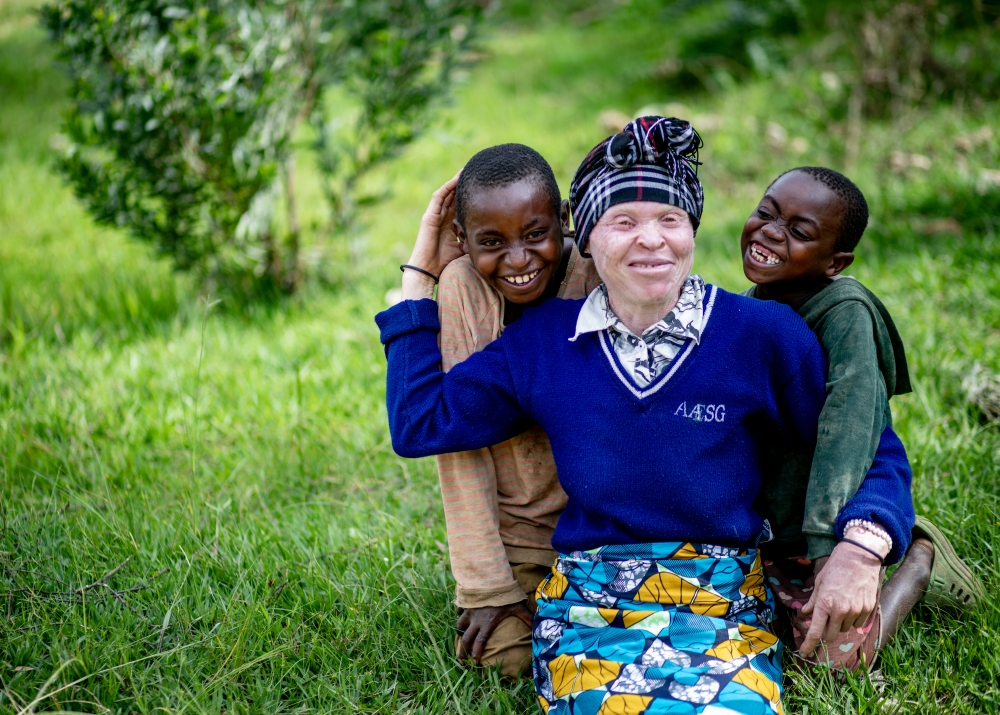 Nyirahabimana and her two sons, Enock and Honoré, pose for a family photo at their home in Rutsiro. Photo: Alice Kayibanda