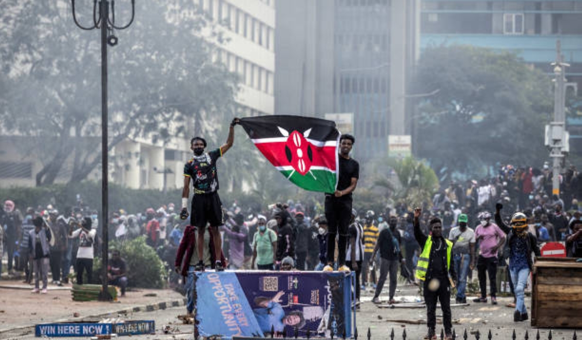 Protesters hold a Kenyan flag outside the Kenyan Parliament after storming the building during a nationwide strike to protest against tax hikes and the Finance Bill 2024 in downtown Nairobi, on June 25, 2024. (Photo by LUIS TATO/AFP via Getty Images)