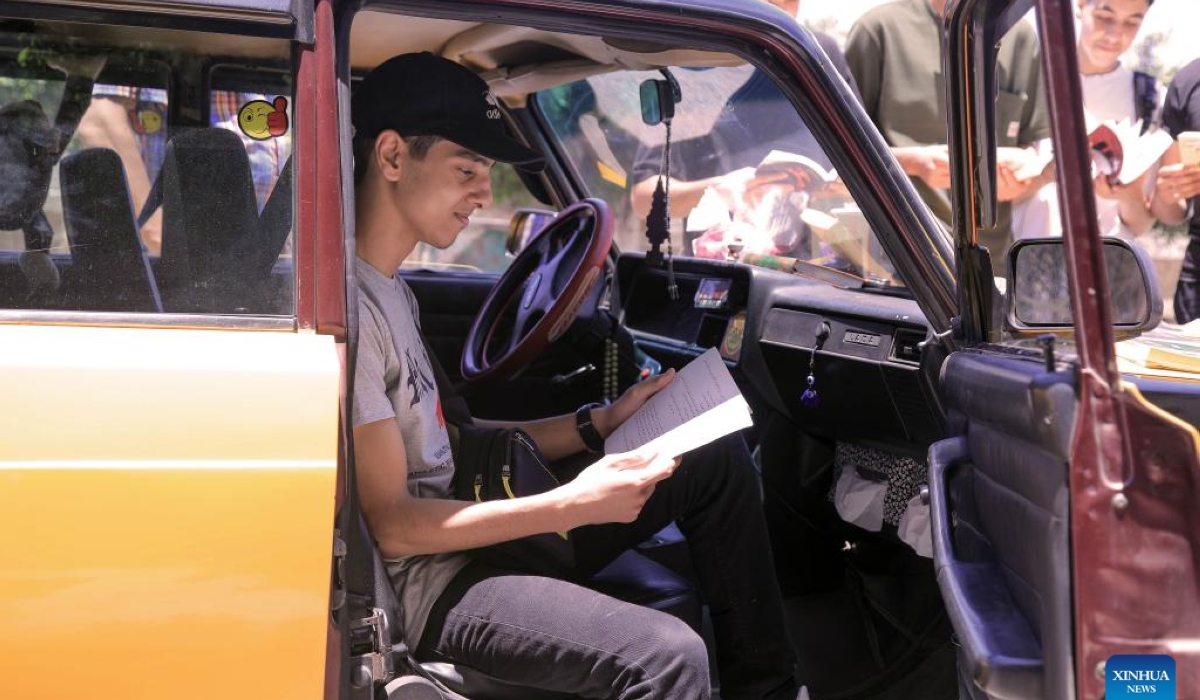 People read books at a mobile taxi library in Alexandria, Egypt, June 29, 2024. (Xinhua/Ahmed Gomaa)