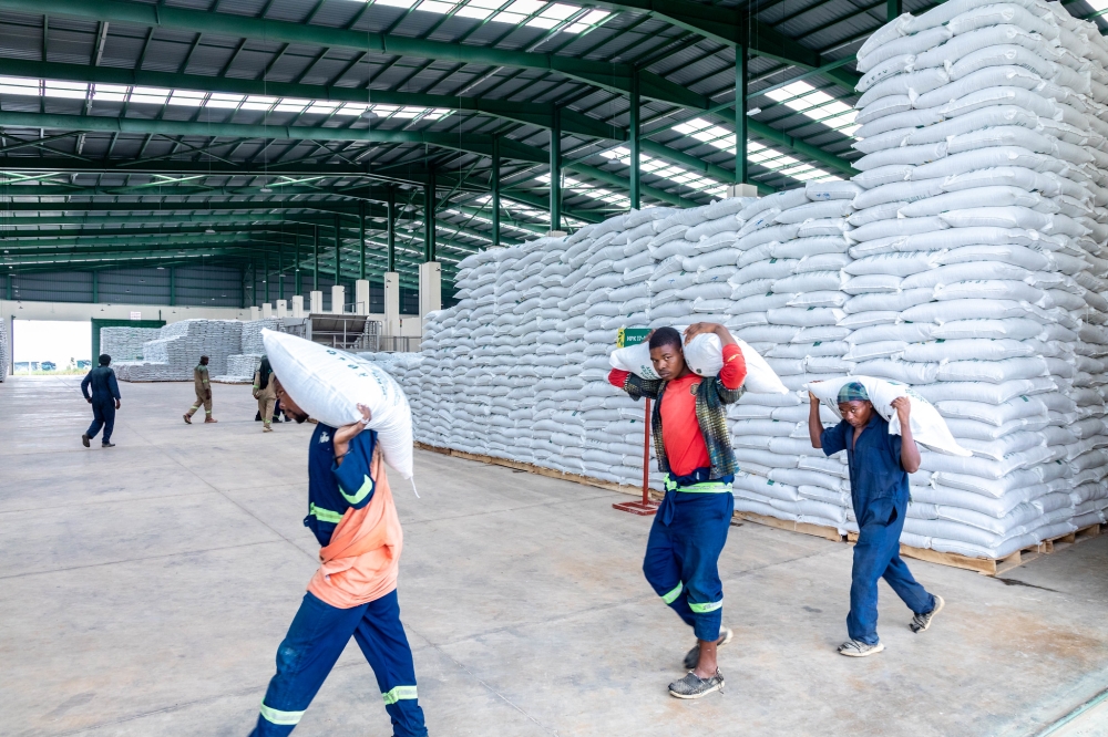 Workers carry sacks of fertilizer at Rwanda Fertilizer Company firm in Bugesera Economic Zone. Photo by Craish Bahizi