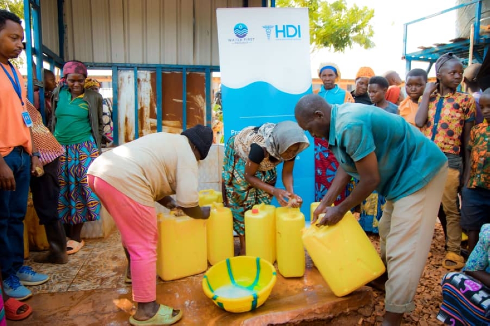 Rweru residents demonstrate ideal container cleaning practices during the launching ceremony on  December, 31, 2024. The WASH programme was funded by the Rob Angel Family.