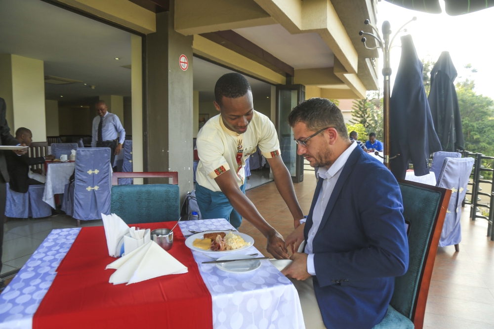 A waiter helps a client at Portofino Hotel in Kigali. Sam Ngendahimana